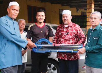 ARIFFIN Deraman menyerahkan sumbangan kepada seorang penduudka di kawasan DUN Alur Limbat