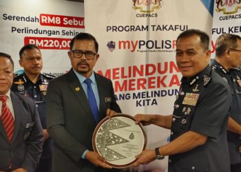 ADNAN Mat Diah menyerahkan cenderamata kepada Mohd. Khalid Ismail selepas merasmikan Perhimpunan Pegawai Awam PDRM Ke-17 Sempena Peringatan Hari Polis Ke-218 di Kota Bharu, Kelantan hari ini-UTUSAN/YATIMIN ABDULLAH.