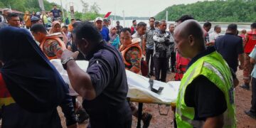 PASUKAN penyelamat membawa mayat mangsa selepas kereta dinaikinya bersama keluarga terjunam ke dalam sungai dalam nahas di Tanjung Agas, Linggi, Port Dickson, pagi tadi.-UTUSAN/MOHD. SHAHJEHAN MAAMIN.