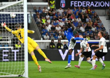 Penyerang Itali Moise Kean (tengah) merembat melepasi penjaga gol Estonia Karl Hein (kiri) untuk menjaringkan gol pertama Itali semasa perlawanan bola sepak kelayakan Kumpulan I Piala Dunia FIFA 2026 antara Itali dan Estonia di Stadio di Bergamo hari ini. - AFP