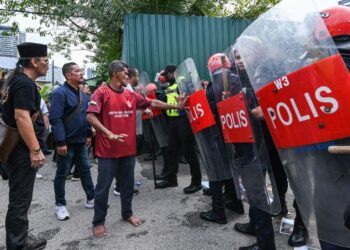 ANGGOTA polis Pasukan Simpanan Persekutuan (FRU) mengawal penduduk yang mendesak untuk masuk ke kawasan perumahan dalam operasi pengosongan flat di Kampung Sungai Baru, Kuala Lumpur, semalam. - UTUSAN/SYAKIR RADIN