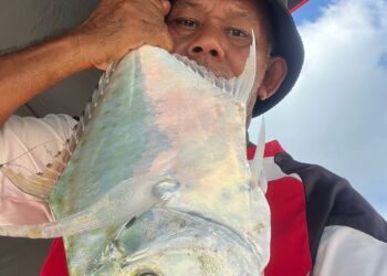 HARIS Hakimi Rohim menunjukkan hasil tangkapan ikan ebek yang dipancingnya di Pantai Bisikan Bayu, Pasir Puteh, Kelantan. 
– UTUSAN/TOREK SULONG