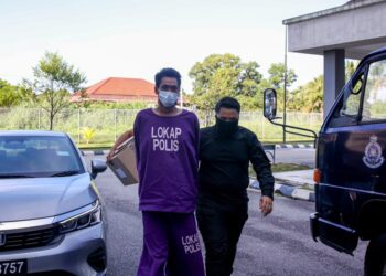 TERTUDUH semasa dibawa oleh polis untuk prosiding perbicaraan di Mahkmah Sesyen Kota Bharu, Kelantan. - UTUSAN/KAMARUL BISMI KAMARUZAMAN