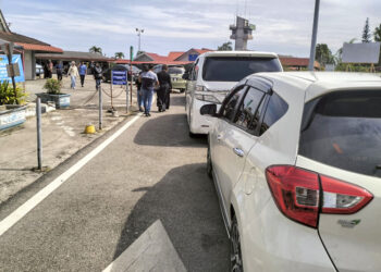 KENDERAAN beratur panjang menunggu giliran menaiki feri di jeti Kompleks Imigresen, Kastam, Kuarantin dan Keselamatan (ICQS) Pengkalan Kubor, Tumpat, Kelantan, semalam. – UTUSAN/ROHANA ISMAIL