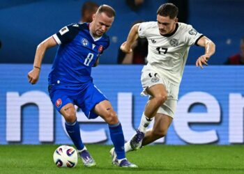 PEMAIN tengah Slovakia, Ondrej Duda (kiri) melepasi kawalan pemain Jerman, Florian Wirtz dalam aksi kelayakan Piala Dunia 2026, semalam.- AFP