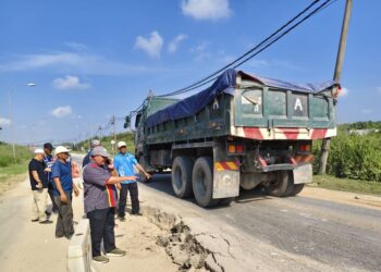 PENDUDUK di Bukit Kerayong menunjukkan mendapan jalan yang membahayakan pengguna di Jalan Iskandar, Bukit Kapar,  Klang, Selangor. – UTUSAN / ABDUL RAZAK IDRIS