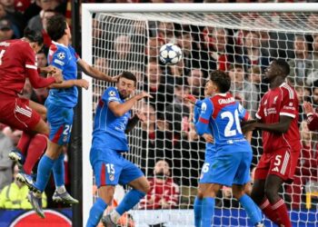 Pemain pertahanan Liverpool, Virgil van Dijk menanduk bola untuk jaringan gol ketiga pasukannya menentang Atletico Madrid dalam pusingan pertama Liga Juara-Juara di Anfield, semalam. - AFP