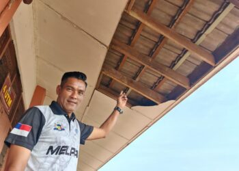 HAIRUL Amin Madon menunjukkan sebahagian siling kelas yang runtuh akibat kayu tetulang bumbung yang reput di SK Serkam Darat, Jasin, Melaka. – UTUSAN/AMRAN ALI