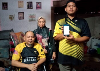 MUHAMMAD Aidil Izzuddin Akhbar Nizam (kanan) bersama ibu bapanya menunjukkan tawaran secara dalam talian kemasukan ke UKM di Felda Kota Gelanggi Dua, Jerantut, Pahang. – UTUSAN/HARIS FADILAH AHMAD