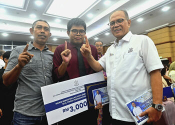 MENTERI Besar Pahang, Datuk Seri Wan Rosdy Wan Ismail (kanan) menyantuni Muhammad Aziq Asri (tengah) yang mendapat keputusan cemerlang 4.0 pada peperiksaan STPM 2024 di Dewan Jubli Perak Sultan Ahmad Shah di Kuantan, Pahang. - UTUSAN/SHAIKH AHMAD RAZIF