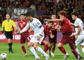 Penyerang Portugal, Cristiano Ronaldo berjaya melepasi halangan pertahanan Armeni dalam aksi kelayakan Piala Dunia di Yerevan, kelmarin. - AFP