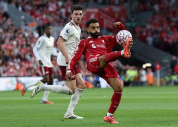 Penyerang Liverpool Liverpool, Mohamed Salah (kanan) melepasi padang ketika pemain tengah Inggeris Arsenal, Declan Rice (kiri) pada perlawanan bola sepak Liga Perdana Inggeris (EPL) antara Liverpool dan Arsenal di Anfield di Liverpool hari ini. - AFP