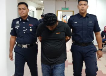 S. Jacson Raj (tengah) diiringi anggota polis selepas keluar dari Mahkamah atas pertuduhan cenderakan pengawal keselamatan di Mahkamah  Majistret, Johor Bahru di sini hari ini.