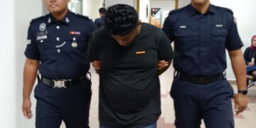 S. Jacson Raj (tengah) diiringi anggota polis selepas keluar dari Mahkamah atas pertuduhan cenderakan pengawal keselamatan di Mahkamah  Majistret, Johor Bahru di sini hari ini.