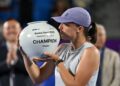 Iga Swiatek dari Poland meraikan kejayaan dengan trofi selepas menewaskan Ekaterina Alexandrova dari Rusia untuk memenangi perlawanan akhir perseorangan wanita pada kejohanan tenis Terbuka Korea di Seoul semalam. - AFP