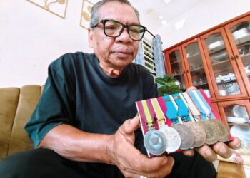 DANIAL Ali bersama pingat yang menjadi simbol jasa dan pengorbanannya demi keamanan negara. – UTUSAN/NURSYASYA NADHIRAH ZABIDI