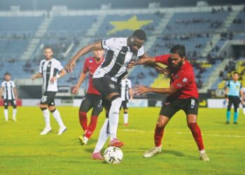 PEMAIN Terengganu FC (TFC), Yann Mabella (tengah) diasak pemain Melaka FC dalam saingan Liga Super di Stadium Sultan Mizan Zainal Abidin, Gong Badak, malam tadi yang berkesudahan skuad Penyu menang 4-0. - MINGGUAN/PUQTRA HAIRRY