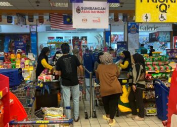 ORANG ramai beratur di kaunter khas Sumbangan Asas Rahmah (SARA) untuk menebus bantuan di sebuah pasar raya di Kuala Terengganu.-UTUSAN/NURSYASYA NADHIRAH ZABIDI