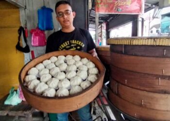 MOHD. Faris Sulaiman menunjukkan pau yang dijual di gerainya di Bandar Jerteh, Besut, Terengganu. – UTUSAN/WAN ZURATIKAH IFFAH WAN ZULKIFLI