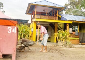 KAMAROZAMAN Yunus membersihkan kawasan chalet yang dilanda banjir di  Kampung Simpang Empat Dalam, Tanjung Malim, Perak.