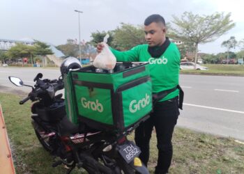 AHMAD Nabil Rosli memilih menjadi penghantar makanan di Kerteh, Kemaman di Terengganu. – MINGGUAN/NIK NUR IZZATUL HAZWANI NIK ADNAN