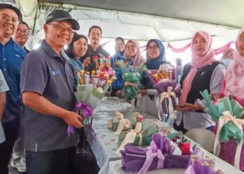 Mustapha Sakmud ( kiri) melawat pameran reka cipta daripada peserta kurssus pendek Kolej Komunit di Felda Umas, Tawau. baru-baru ini. – utusan/BESSE AISYAH