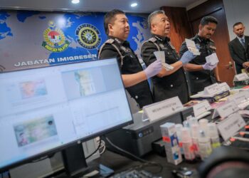 ZAKARIA  Shaaban (tengah) menunjukkan barangan kes selepas sidang akhbar berkenaan 'Operasi Khas Imigresen' di Putrajaya. - UTUSAN/FAIZ ALIF ZUBIR