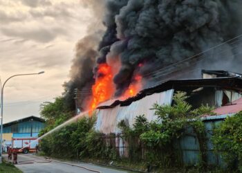 Anggota bomba memadam kebakaran yang memusnahkan sebuah gudang di Estet Perindustrian Bintawa pagi tadi.