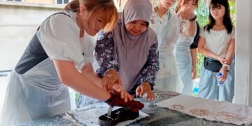 SEORANG pelajar dari Jepun (kiri) mencanting batik dengan dibantu pengasas Lambo Sari, Sarina Said dalam program mobiliti antarabangsa, Culture N Connect di Kuala Nerus, Terengganu baru-baru ini.