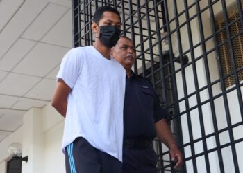 TERTUDUH yang didakwa cuba membunuh isterinya dengan mengelar leher wanita terbabit sebelum mencederakan dirinya sendiri diiringi oleh seorang anggota polis ketika tiba di Mahkamah Sesyen Balik Pulau, Pulau Pinang hari ini.-UTUSAN/DANIAL SAAD