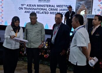SAIFUDDIN Nasution Ismail diberi penerangan oleh seorang pegawai mengenai persiapan terakhir AMMTC Ke-19 di sebuah hotel di Banda Hilir, Melaka. - UTUSAN/AMRAN MULUP