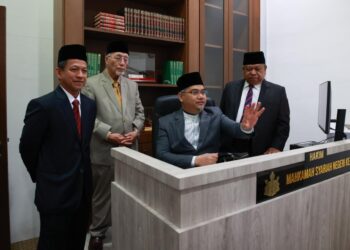 MOHD. Asri Mat Daud (duduk) sambil memperkatakan sesuatu kepada Ibrahim Deris semasa  perasmian Dewan Mahkamah Teknologi Mahkamah Syariah Kelantan Kompleks Mahkamah Syariah Kelantan, Kota Bharu, Kelantan hari ini-UTUSAN/KAMARUL BISMI KAMARUZAMAN.