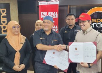 ERWAN Rizal Ali Napiah (kanan) bertukar dokumen perjanjian kerjasama antara Ekspres Perdana dan Kelantan TRW dengan Laili Ismail di Mukim Telok Mesira, Bachok, Kelantan hari ini. - UTUSAN/MUSTAQIM MOHAMED