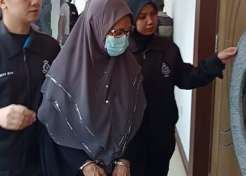 HAMIMAH Yakub dibawa anggota polis ke Mahkamah Sesyen Shah Alam, Selangor hari ini. - UTUSAN/ISKANDAR SHAH MOHAMED