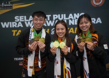 ATLET  wushu negara, Tan Cheong Min (tengah), Si Shin Peng (kiri) dan Lee Jia Rong (kanan) yang memenangi emas Kejuaraan Dunia Wushu 2025 ketika tiba di Lapangan Terbang Antrabangsa Kuala Lumpur (KLIA) Terminal 1, di sini, hari ini.-UTUSAN/FAISOL MUSTAFA