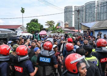 PASUKAN polis mengawal keadaan di Kampung Sungai Baru, Kampung Baru, Kuala Lumpur susulan operasi pengusiran baki penduduk hari ini. - UTUSAN/SYAKIR NORDIN