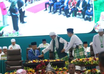 ABDUL Hadi Awang bersalaman dengan Tan Sri Muhyiddin Yassin pada majlis perasmian Muktamar Tahunan Pas Ke-71 di Kompleks Pas Kedah, hari ini.-UTUSAN
