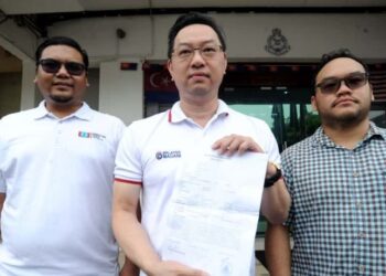 JIMMY Puah Wee Tse menunjukkan laporan polis selepas menerima e-mel berunsur ugutan yang mendakwa memiliki gambar menyerupai dirinya bersama seorang individu lain di atas katil di Balai Polis Permas Jaya, Johor Bahru, hari ini. - UTUSAN/RAJA JAAFAR ALI