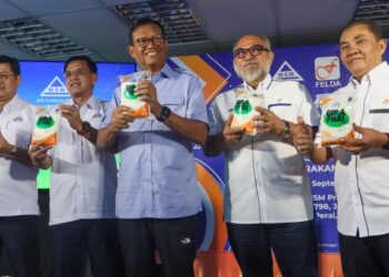 AHMAD Shabery Cheek (tengah) menunjukkan Gula Prai Edisi Khas Felda pada majlis pelancaran gula tersebut di MSM Prai, Butterworth, Pulau Pinang.-UTUSAN/DANIAL SAAD