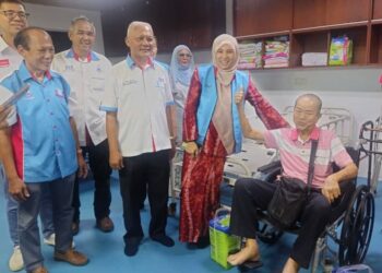 Nurul Izzah (dua dari kanan) menyantuni seorang pesakit di pusat khidmat  kesihatan Pejabat Keadilan Tawau.-UTUSAN/BESSE AISYAH