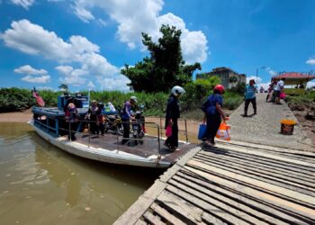 PENUMPANG menaiki bot penambang warisan yang masih mengenakan tambang RM1 seorang untuk menyeberangi di Sungai Perak di Teluk Intan, Perak. – UTUSAN/AIN SAFRE BIDIN