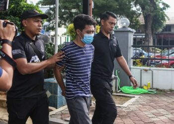 SYED Al Iqbal Syed Shahruddin diiring anggota polis ketika dihadapkan ke Mahkamah Majistret, Gurun, Kedah atas dua pertuduhan membunuh. - UTUSAN/SHAHIR NOORDIN