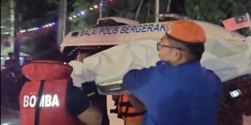 ANGGOTA bomba bersama orang awam mengangkat jenazah mangsa yang ditemui kira-kira 150 meter dari lokasi kejadian di Pantai Puteri, Melaka malam ini. - UTUSAN/AMRAN ALI