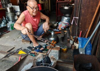 YONG Ah Kow sedang menyiapkan peralatan logam tempahan pelanggan di bengkel kecilnya di Jalan Hang Kasturi, Melaka.-UTUSAN/AMRAN ALI