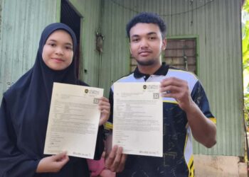 PUTERI Nardiana Aleesya Mat Zakar dan Muhammad Haikal Danial Dillah menunjukkan surat tawaran kemasukan ke Universiti Sultan Zainal Abidin (UniSZA) di Kampung Kuala Akob, Hulu Terengganu. - . UTUSAN/ NOOR HAYATI MAMAT
