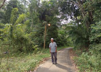 MOHD. Zaharin Ahmad menunjukkan laluan masuk ke Kampung Miku Lama, Rembau-UTUSAN/NOR AINNA HAMZAH.