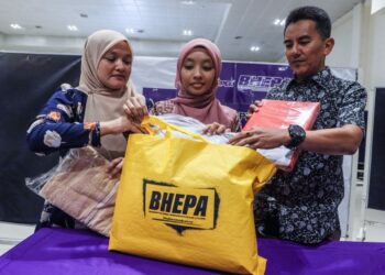 NUR Elisa Syuhada (tengah) bersama ibunya, Siti Nazirah Mohd Alias, 46, (kiri) dan ayahnya, Shamsul Ikram Mohd Yasin, 47,  melihat kit asas yang diterima selepas mendaftar pelajar baharu USM di Dewan Utama Desasiswa USM Pulau Pinang.-UTUSAN/DANIAL SAAD