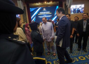 ANWAR Ibrahim beramah mesra dengan kakitangan awam pada perhimpunan bulanan Kementerian Kewangan di Putrajaya. - UTUSAN/FAISOL MUSTAFA