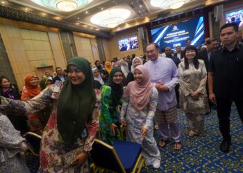 ANWAR Ibrahim beramah mesra dengan kakitangan awam pada perhimpunan bulanan Kementerian Kewangan di Putrajaya. - UTUSAN/FAISOL MUSTAFA