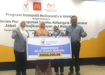SHAMSIDAR Yahya (kiri sekali) menyampaikan replika cek RM50,000 bagi fasiliti Bilik Terapi Sensori Integrasi kepada Pengetua Rumah Taman Sinar Harapan Tuanku Ampuan Najihah Khairunnisa Zainal pada Program Bulan Komuniti McDonald’s & RMHC 2025 dengan kerjasama JKM di Seremban hari ini.-UTUSAN /NUR SHARIEZA ISMAIL